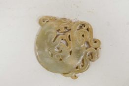 A Chinese white jade pendant with carved and pierced dragon decoration, 3" diameter