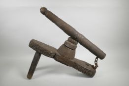 An Indian carved wood grinder, possibly for betel nut, 20" long, leg missing