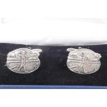 A pair of silver cufflinks with chased and engraved decoration of golfers
