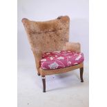A mid century Strongbow wing back armchair, with tub shaped back
