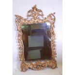 A carved and pierced giltwood framed wall mirror with antiqued glass, 50" x 30"