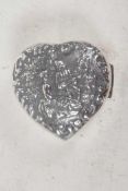 A small sterling silver heart shaped pill box with embossed figural decoration