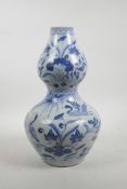 A Chinese Ming style blue and white porcelain double gourd vase decorated with waterfowl on a lotus