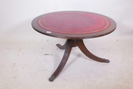 A mahogany occasional table with leather inset top, raised on a turned column with reeded splay supp
