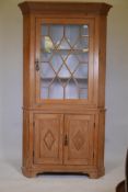 A large Irish pine two section corner cupboard with single astragal glazed door over two door cupboa