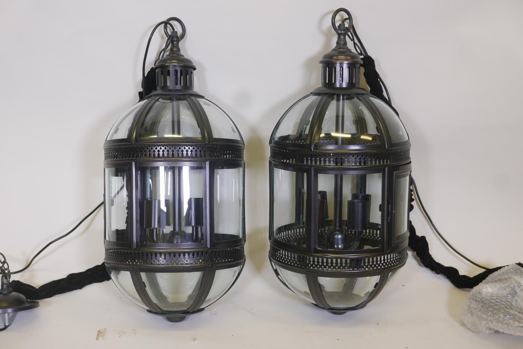 A pair of contemporary bronzed metal pendant lanterns, 27" long