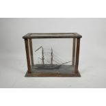 A scratch built diorama/model of a two masted ship, in a glass and wood case, 11½" x 5"