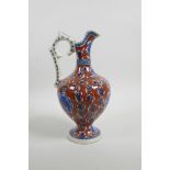 An early C20th Turkish Kutahya pottery ewer with traditional floral decoration, repair to handle, 10