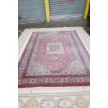 A pink ground carpet decorated with an all over geometric floral pattern, 108" x 141"