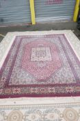 A pink ground carpet decorated with an all over geometric floral pattern, 108" x 141"