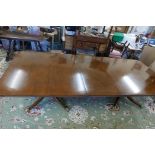 A good Regency style twin pedestal dining table with extra leaf, raised on turned column columns and