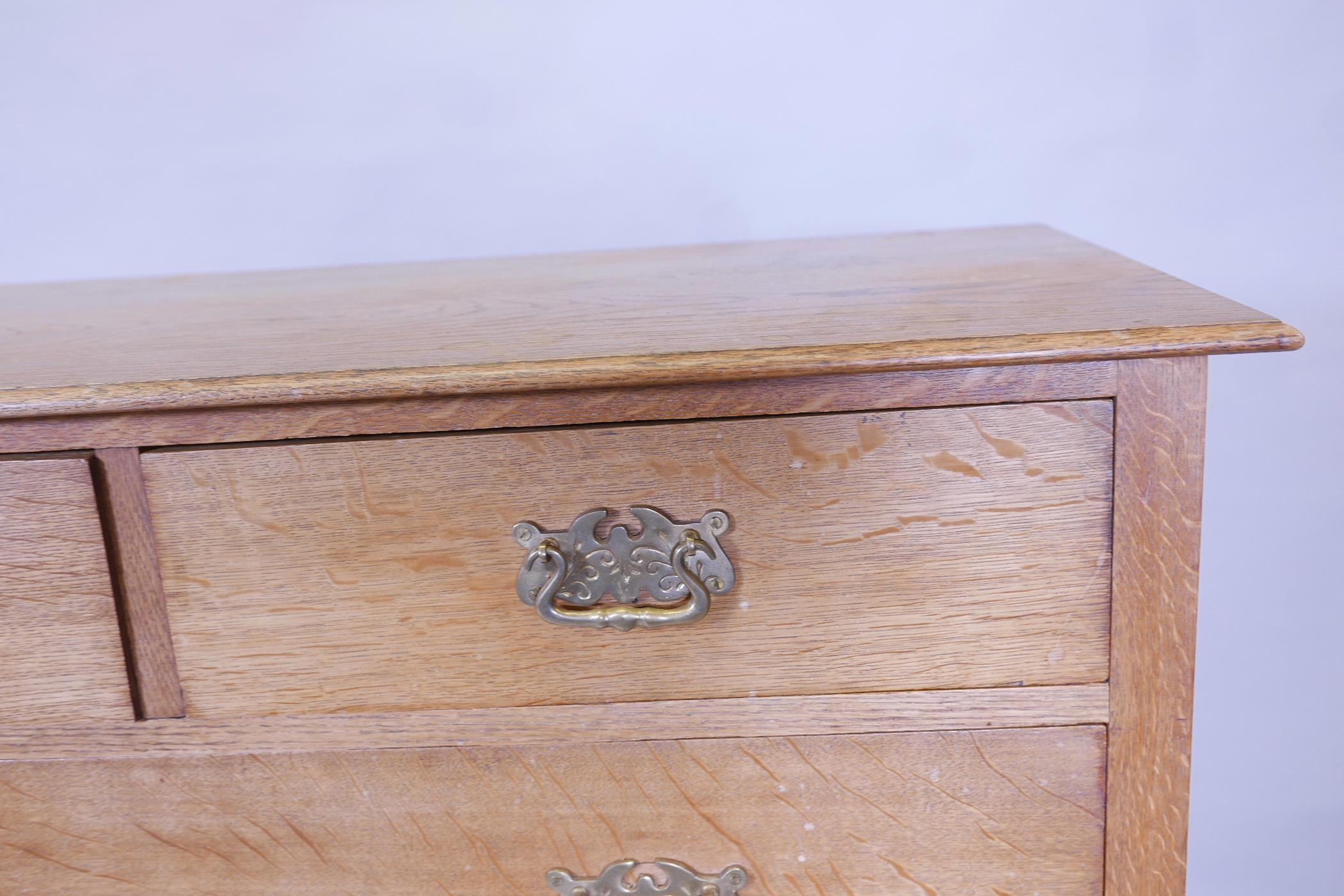An early C20th oak chest of two over three drawers, with brass handles, raised on carved stile - Image 2 of 3