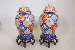 A pair of Oriental ceramic jars and covers, decorated with bright enamels in the Imari style, with