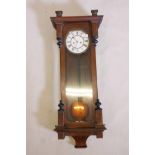 A C19th walnut cased weight driven Vienna wall clock with white enamel face and Roman numerals,