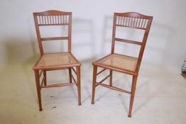 A pair of Edwardian walnut bedroom chairs with cane seats, 32" high