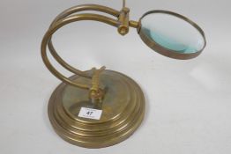 A brass desk top magnifying glass, glass 4" diameter