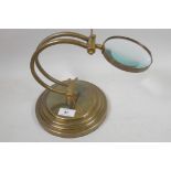 A brass desk top magnifying glass, glass 4" diameter