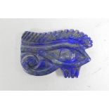 An Egyptian lapis lazuli carved ornament in the form of the Eye of Ra, 2" x 1½"