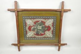 A C19th beadwork panel depicting a rose in an elaborate surround mounted in a mahogany cruciform