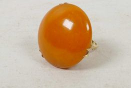 A 9ct gold dress ring set with a large circular amber stone, size 'O'