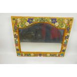 A shaped bevelled glass wall mirror in beadwork decorated frame, 18½" x 14½" overall