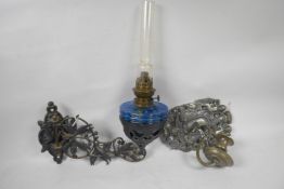 An ornate cast iron wall mounted oil lamp bracket, 12" long, together with a cast iron wall