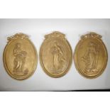 Three gilt plaster plaques with raised decoration depicting classical women, 11" x 15"