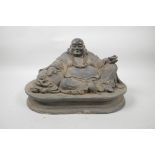 A Chinese bronze of a rotund Buddha reclining on a sack, with gilt patina, 13" wide, 8" high