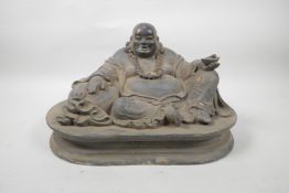 A Chinese bronze of a rotund Buddha reclining on a sack, with gilt patina, 13" wide, 8" high