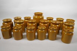 A set of eighteen earthenware storage jars with brown treacle glaze, largest 6½" high