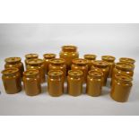 A set of eighteen earthenware storage jars with brown treacle glaze, largest 6½" high