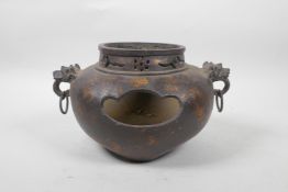 A Chinese bronzed metal censer on tripod feet with gilt patina, two dragon mask handles and
