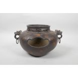 A Chinese bronzed metal censer on tripod feet with gilt patina, two dragon mask handles and