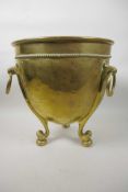 A Soutterware brass jardiniere with three ring handles and heavy cast scroll legs, 12" high, 11½"
