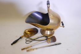 A C19th brass helmet coat scuttle with ebonised handles together with a matching shovel and poker,