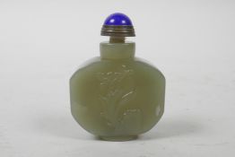 A Chinese celadon jade snuff bottle with carved floral decoration, character inscription verso,