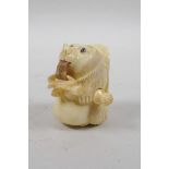 A bone tape measure carved in the form of a bear, 2" high