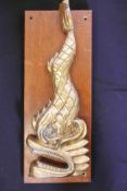 Half of a Chinese brass ship's bell bracket, cast as a sea monster, 18" long, mounted on a wooden