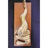 Half of a Chinese brass ship's bell bracket, cast as a sea monster, 18" long, mounted on a wooden