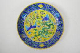 A Chinese porcelain cabinet dish decorated with a dragon and phoenix chasing the flaming pearl in