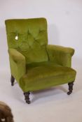 A Howard and Sons style retro upholstered armchair with buttoned upholstery on turned front supports