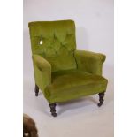 A Howard and Sons style retro upholstered armchair with buttoned upholstery on turned front supports