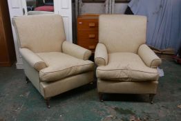 A pair of contemporary armchairs, with scroll arms, raised on turned oak supports