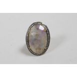 A vintage dress ring set with a large oval facet cut hardstone encircled by marcasites,