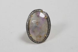 A vintage dress ring set with a large oval facet cut hardstone encircled by marcasites,