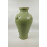 A Chinese olive green glazed pottery vase decorated with four raised underglaze god masks, 18" high