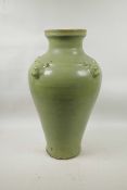 A Chinese olive green glazed pottery vase decorated with four raised underglaze god masks, 18" high