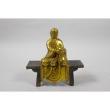 A Chinese gilt bronze figure of Buddha seated on a bench, 5½" high