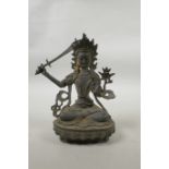 A Tibetan bronze of buddha seated on a lotus throne, carrying a sword, 8" high