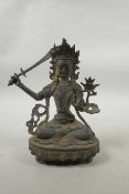 A Tibetan bronze of buddha seated on a lotus throne, carrying a sword, 8" high